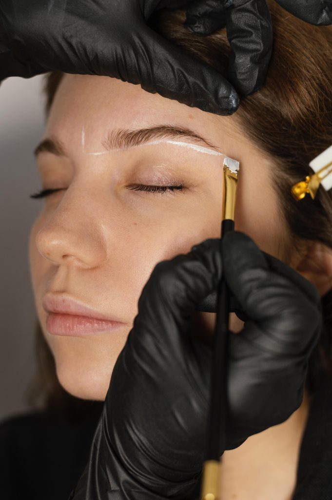 Services woman getting eyebrow treatment from beautician